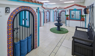 Luxury boarding villas with Talavera tiled archways around a courtyard fountain