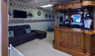 Pet lounge with a wooden bar, leather couch and nautical signal flags