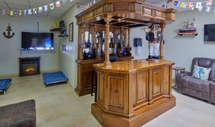Nautical lounge with a wooden bar, fireplace and elevated pet cots