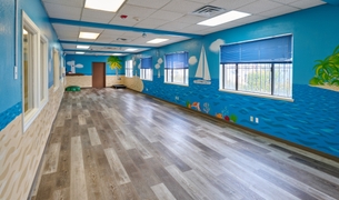 Indoor play room painted with a beach and ocean mural
